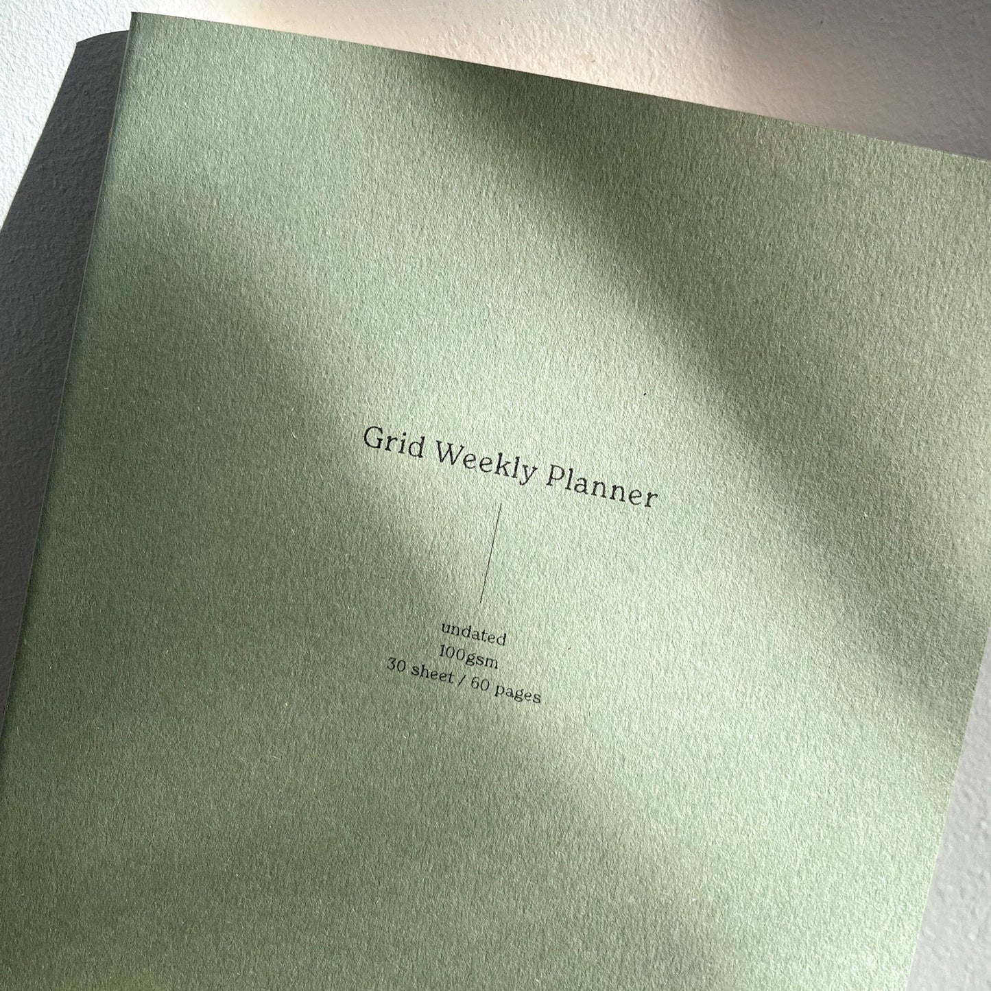 A green Grid Weekly Planner with a simple text title on the cover.
