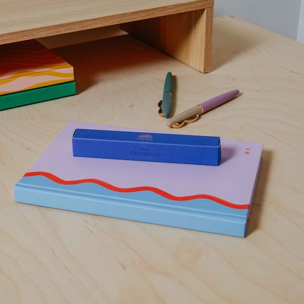 A blue packaging box for a pen from the Pencil Me In stationery shop.