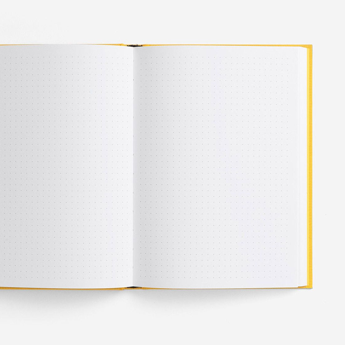 A open notebook with yellow binding and grid dot paper from the Pencil Me In stationery shop.