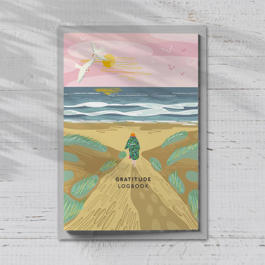 A gratitude logbook with an image on a woman on the beach from the Pencil Me In stationery shop. 