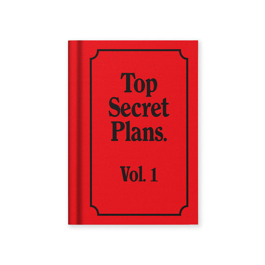 A Red book titled 'Top Secret Plans Vol. 1' from the Pencil Me In stationery shop. 