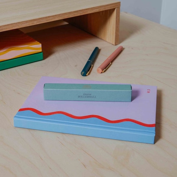 A mint green pen packaging box for the Pencil Me In stationery shop. 