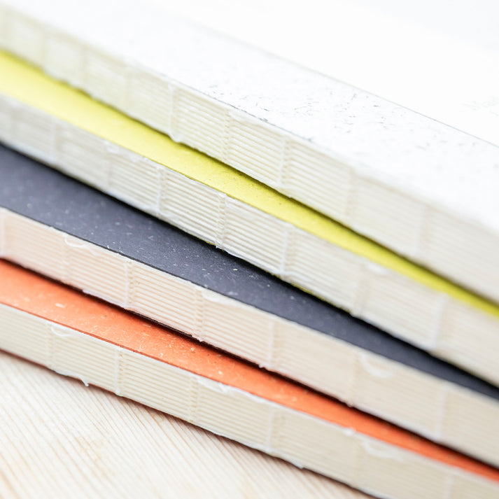 Stack of colorful notebooks from the Pencil Me In stationery shop. 